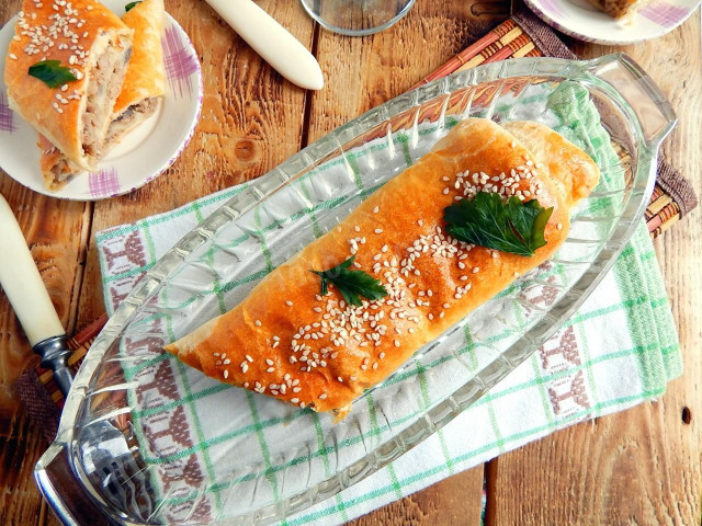 Puff pastry roll with minced meat in the oven