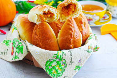 Sweet pumpkin pies from yeast dough in oven