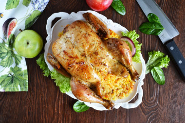 Whole chicken stuffed with rice in oven