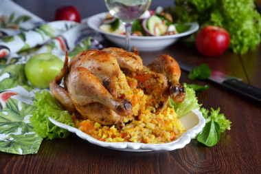 Whole chicken stuffed with rice in oven