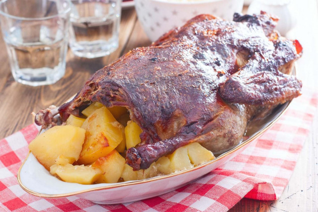 Duck in the oven in a sleeve with stuffed potatoes