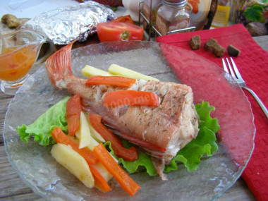 Sea bass baked with potatoes in the oven in foil