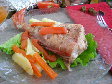 Sea bass baked with potatoes in the oven in foil