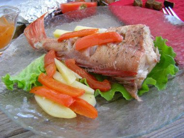 Sea bass baked with potatoes in the oven in foil