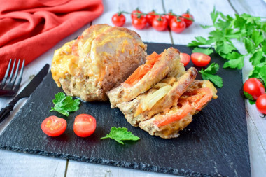 Pork with cheese and tomato in foil in the oven