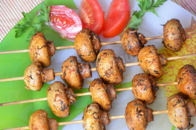 Shish kebab of champignons in the oven on skewers