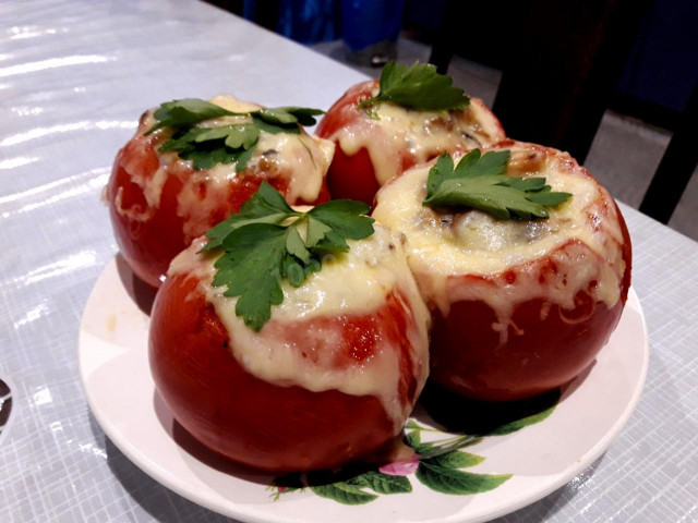 Tomatoes stuffed with chicken and cheese in the oven