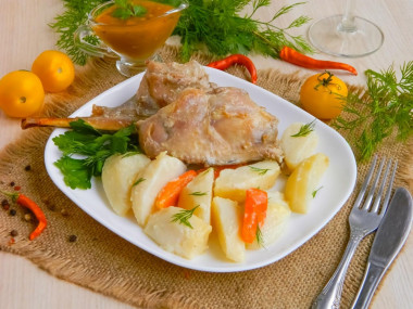 Rabbit baked in sour cream sauce with vegetables in the oven