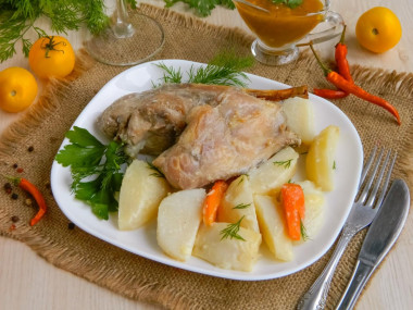 Rabbit baked in sour cream sauce with vegetables in the oven