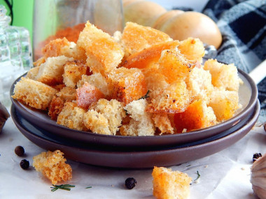 Bread croutons with black pepper and basil in the oven