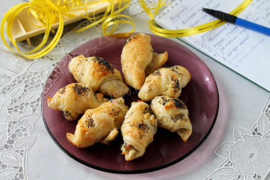 Puff pastry bagels with red fish and cheese in the oven