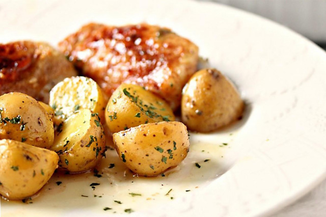 Chicken thighs in tomato sauce with potatoes in the oven