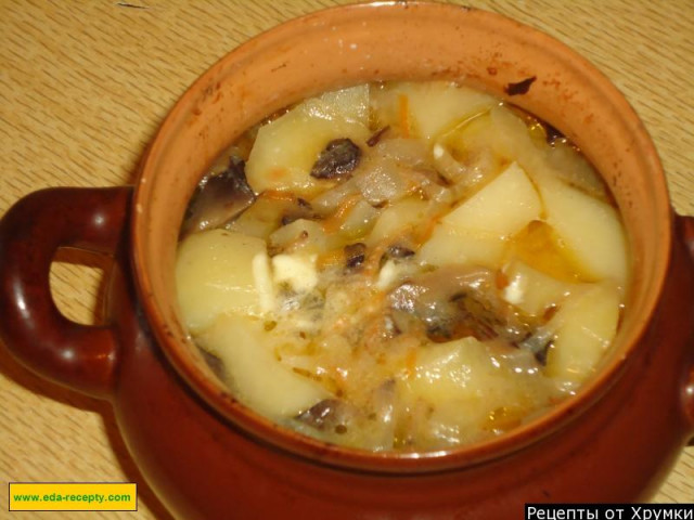 Roast pork and potatoes in pots with mushrooms