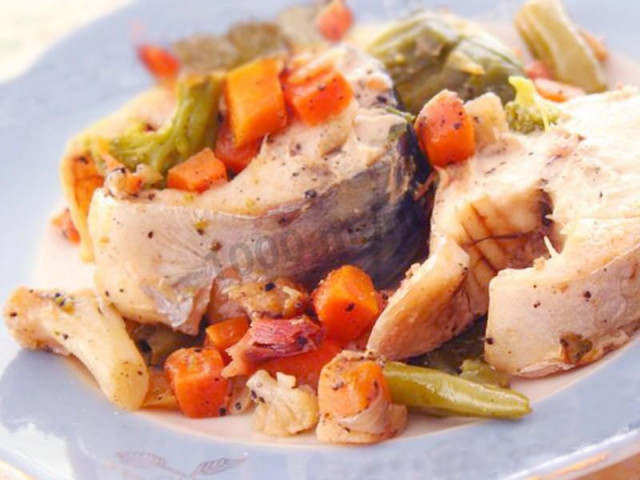 Mackerel with potatoes, onions, carrots and spices in foil