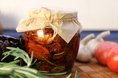 Dried tomatoes with garlic, basil and rosemary in oil