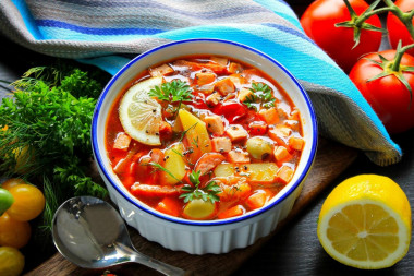 Solyanka soup with olives, sausage and lemon