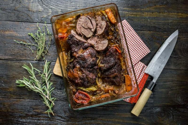 Baked beef shank with vegetables in beer