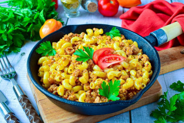 Pasta with minced meat and tomato paste in a frying pan