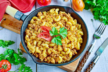 Pasta with minced meat and tomato paste in a frying pan