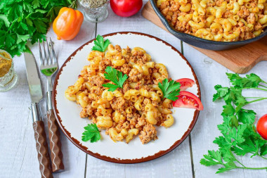 Pasta with minced meat and tomato paste in a frying pan