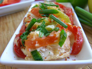 Pink salmon with tomatoes and onions in foil in the oven