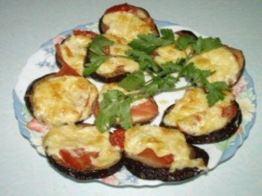 Eggplant in the oven with hard cheese, tomatoes and herbs