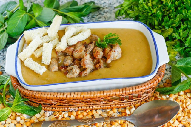 Mashed pea soup in a slow cooker with smoked pork belly