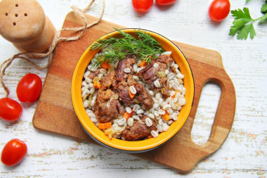 Pearl porridge with stewed meat in a frying pan