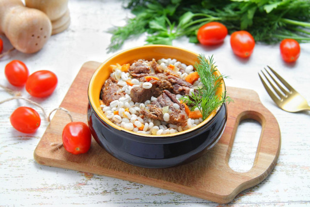 Pearl porridge with stewed meat in a frying pan