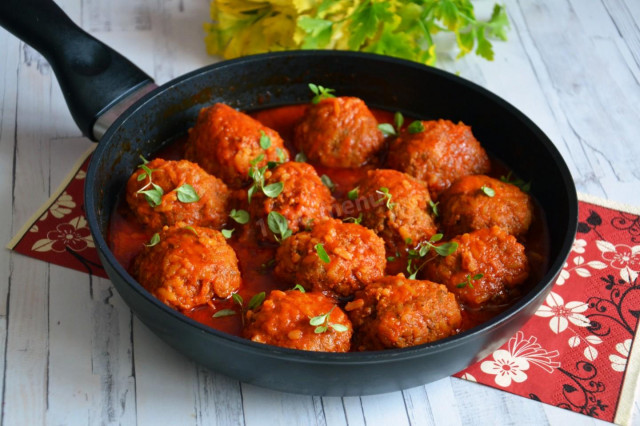 Beef meatballs with rice in a frying pan