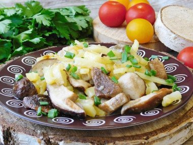 Potatoes with white fried mushrooms in a frying pan