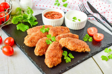 Crispy breaded chicken wings in a frying pan