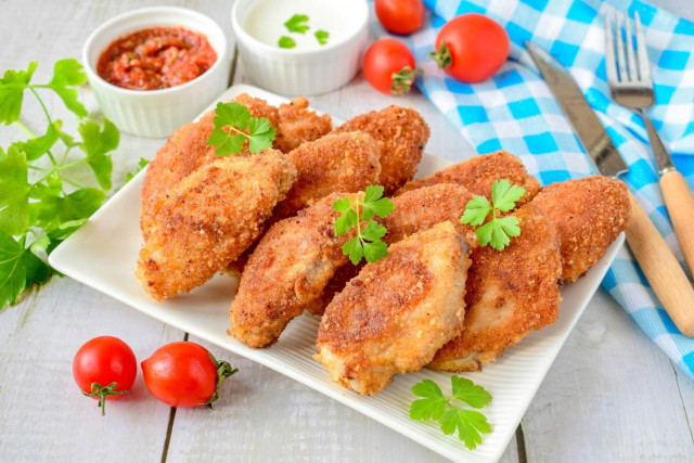 Crispy breaded chicken wings in a frying pan