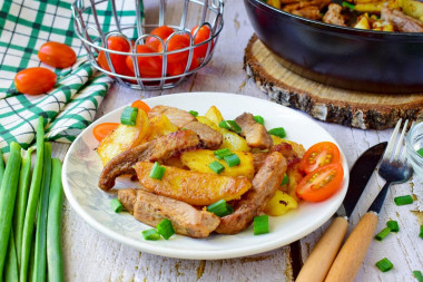 Fried potatoes with meat on frying pan