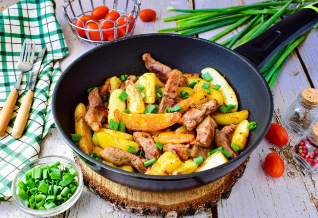 Fried potatoes with meat on frying pan