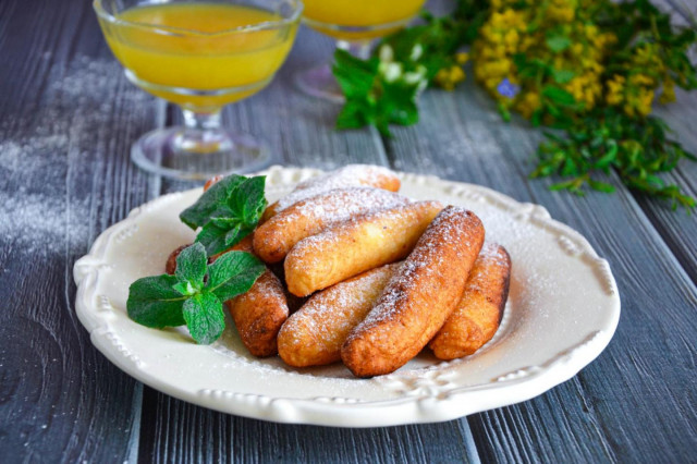 Cottage cheese sticks fried in oil on frying pan