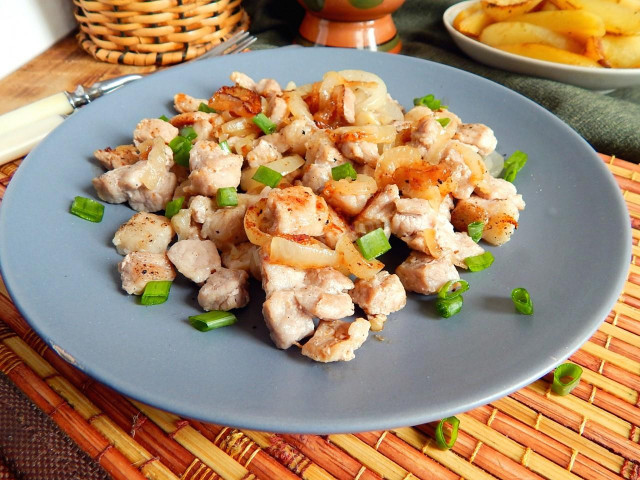 Fried meat with onions in a frying pan