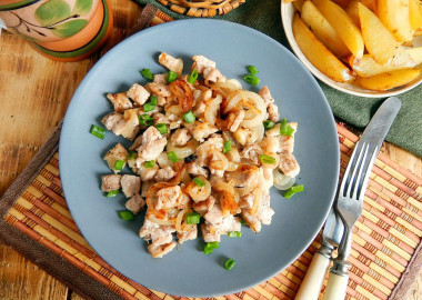 Fried meat with onions in a frying pan