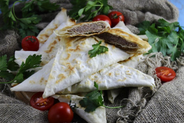 Lazy pita bread chebureks with minced meat in a frying pan