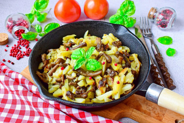 Fried potatoes with honey mushrooms in a frying pan