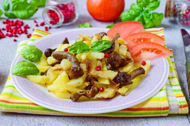 Fried potatoes with honey mushrooms in a frying pan