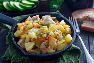 Fried potatoes with chicken in a frying pan