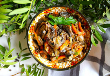 Fried mushrooms with onions and carrots in a frying pan