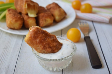 Fried suluguni cheese in a pan in breadcrumbs