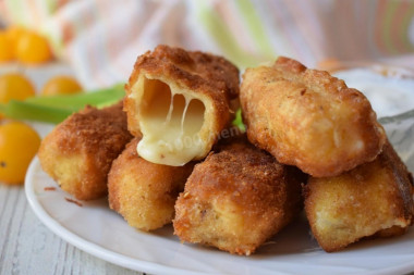 Fried suluguni cheese in a pan in breadcrumbs