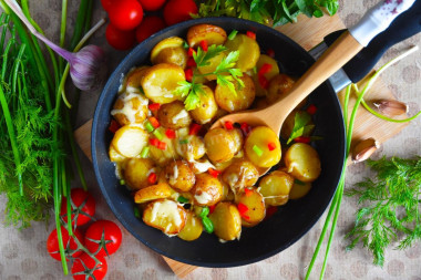 Fried potatoes with cheese in a frying pan