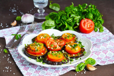 Fried eggplant slices in a pan with garlic