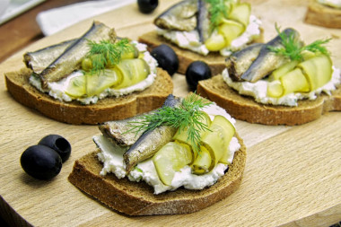 Sandwiches with sprats on black bread