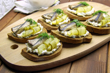 Sandwiches with sprats on black bread