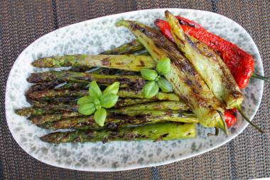 Green asparagus on charcoal on the grill